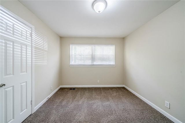 carpeted spare room with baseboards