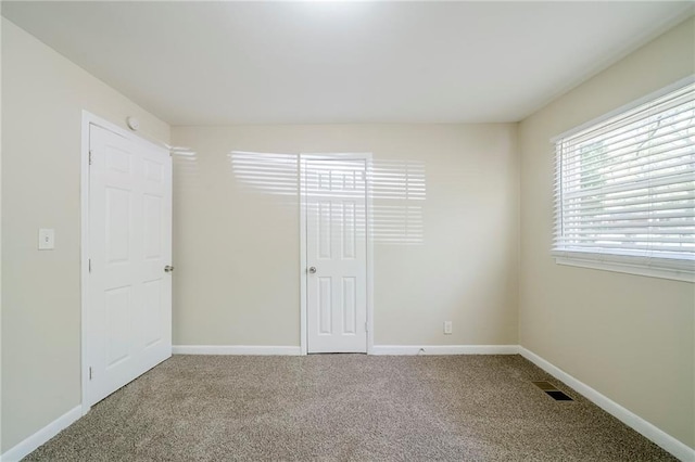 unfurnished bedroom featuring baseboards, visible vents, and carpet flooring