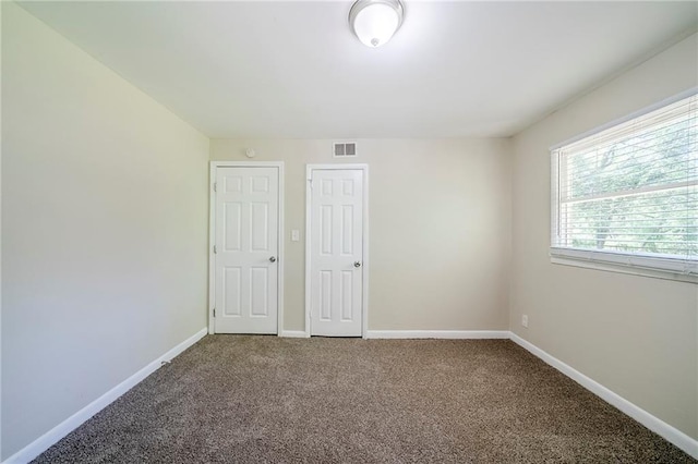 spare room featuring visible vents, carpet floors, and baseboards