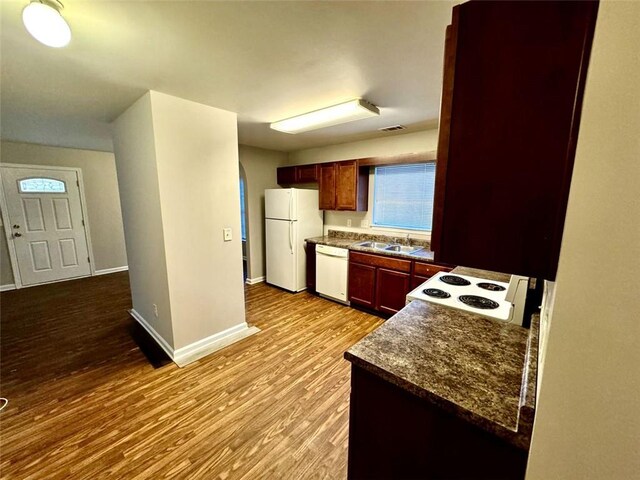 kitchen with white appliances, sink, and light hardwood / wood-style floors