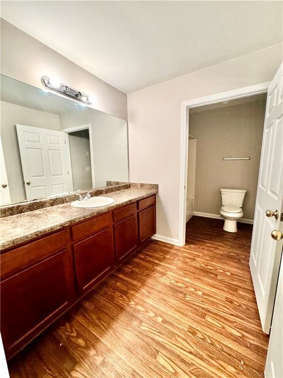 bathroom featuring toilet, vanity, and wood-type flooring