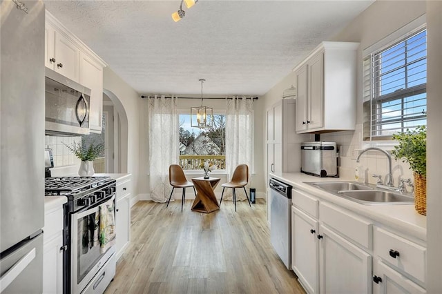 kitchen featuring a healthy amount of sunlight, white cabinetry, sink, and appliances with stainless steel finishes