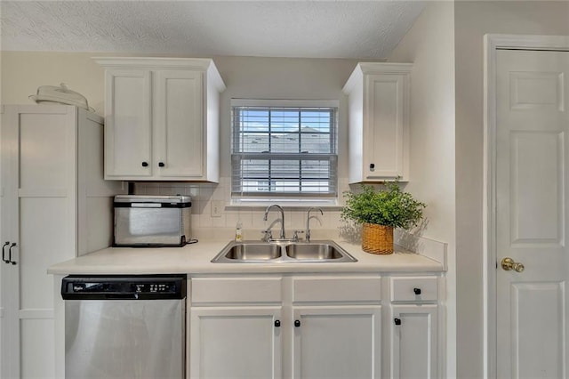 kitchen with sink, stainless steel dishwasher, backsplash, a textured ceiling, and white cabinets