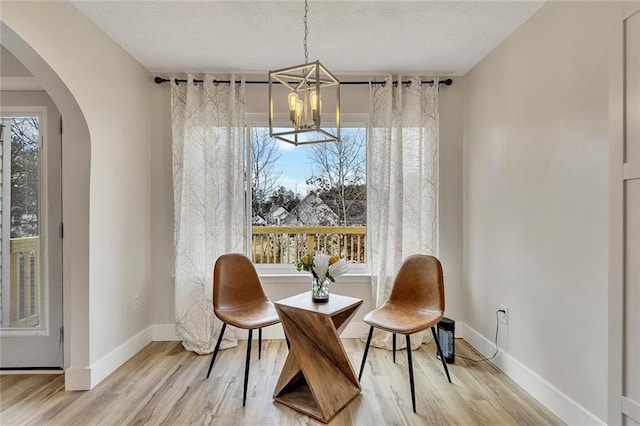 living area with light wood-type flooring and an inviting chandelier