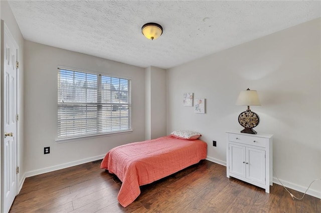 bedroom with dark hardwood / wood-style flooring and a textured ceiling