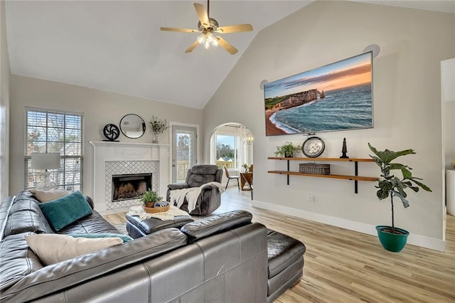 living room with ceiling fan, a fireplace, a healthy amount of sunlight, and light hardwood / wood-style floors