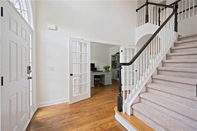 4108 Wyndam Hill Dr, Suwanee, GA 30024 - foyer entrance with a high ceiling, stairway, wood finished floors, and french doors
