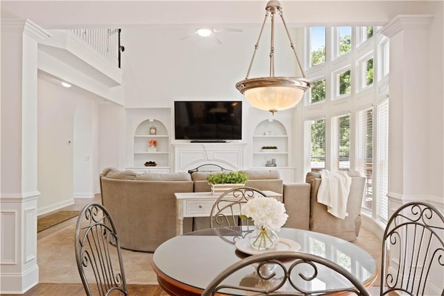 4108 Wyndam Hill Dr, Suwanee, GA 30024 - dining area featuring built in shelves, a high ceiling, and a fireplace