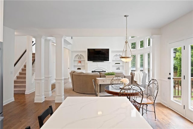 4108 Wyndam Hill Dr, Suwanee, GA 30024 - dining room with wood finished floors, a fireplace, built in features, and stairway