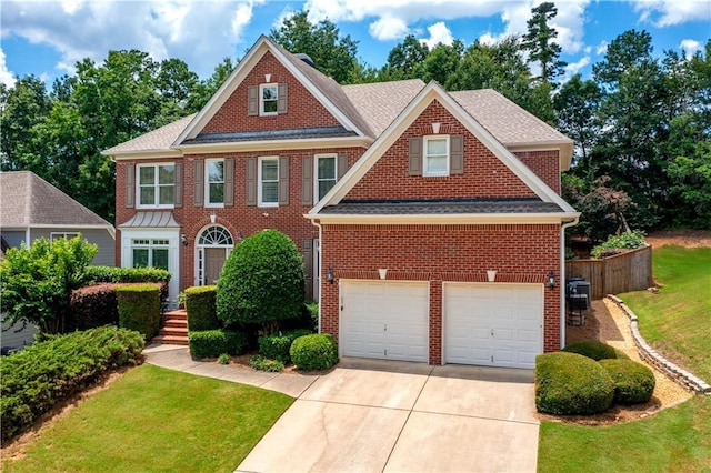 4108 Wyndam Hill Dr, Suwanee, GA 30024 - colonial-style house featuring a garage, driveway, brick siding, and a front lawn