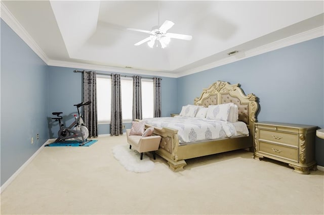 carpeted bedroom with a tray ceiling, visible vents, ornamental molding, ceiling fan, and baseboards