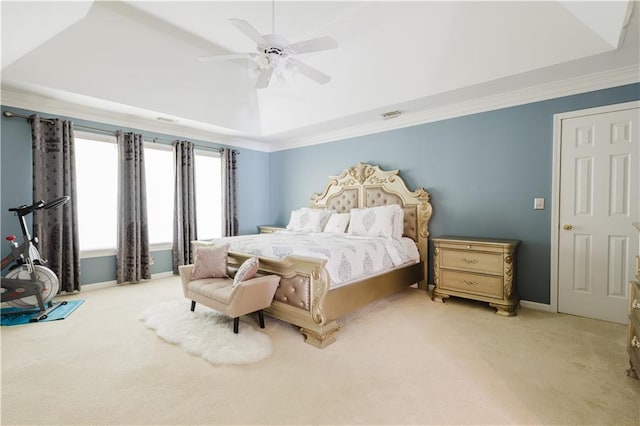 bedroom with a tray ceiling, carpet flooring, crown molding, and visible vents