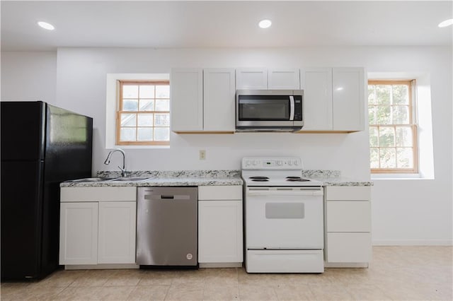 kitchen with appliances with stainless steel finishes, a wealth of natural light, a sink, and recessed lighting