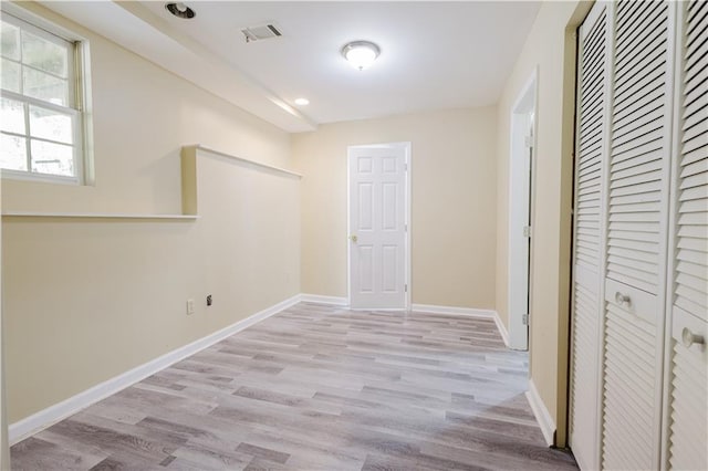 hallway featuring light wood-style floors, visible vents, baseboards, and recessed lighting