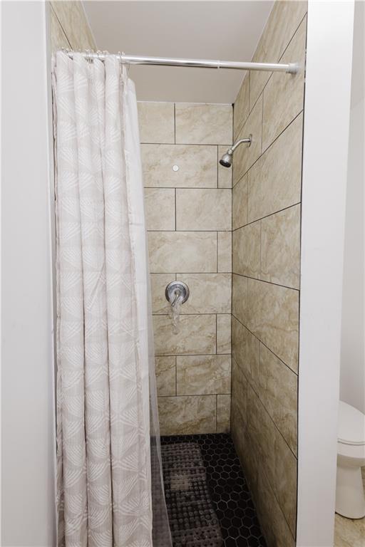 bathroom featuring a shower stall and toilet