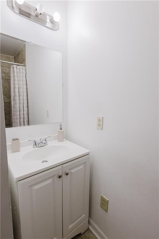 full bathroom featuring curtained shower, baseboards, and vanity