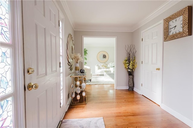 foyer featuring light wood-style floors, baseboards, and ornamental molding