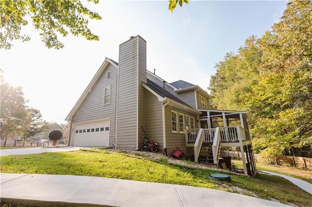 view of home's exterior with a sunroom, stairs, concrete driveway, and a yard