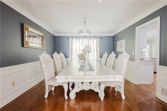 dining room featuring wainscoting, wood finished floors, and crown molding