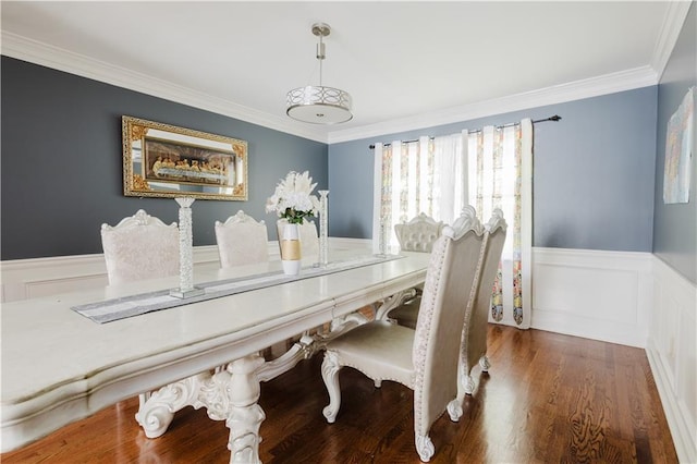 dining room with ornamental molding, a wainscoted wall, and wood finished floors