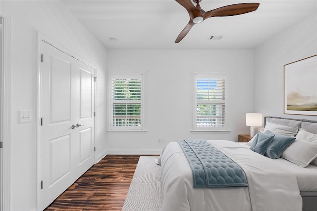 bedroom featuring dark wood-type flooring, ceiling fan, and a closet