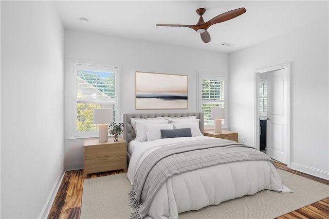 bedroom with ceiling fan, hardwood / wood-style floors, and multiple windows