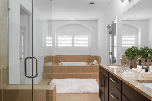 bathroom with vanity, plenty of natural light, plus walk in shower, and tile patterned flooring