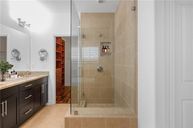 bathroom with tile patterned floors, a shower with shower door, and vanity