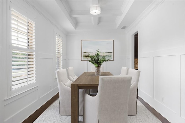 dining area featuring ornamental molding, coffered ceiling, light hardwood / wood-style flooring, and beamed ceiling