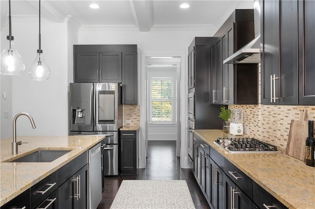 kitchen featuring stainless steel appliances, sink, light stone countertops, hanging light fixtures, and wall chimney range hood