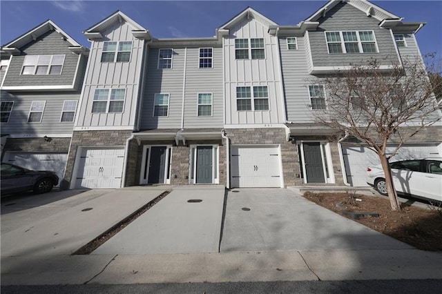 multi unit property featuring board and batten siding, stone siding, an attached garage, and concrete driveway