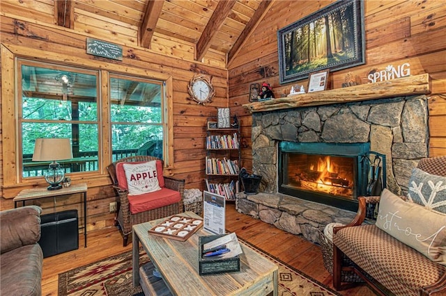 sitting room with a fireplace, vaulted ceiling with beams, wood ceiling, wooden walls, and hardwood / wood-style floors