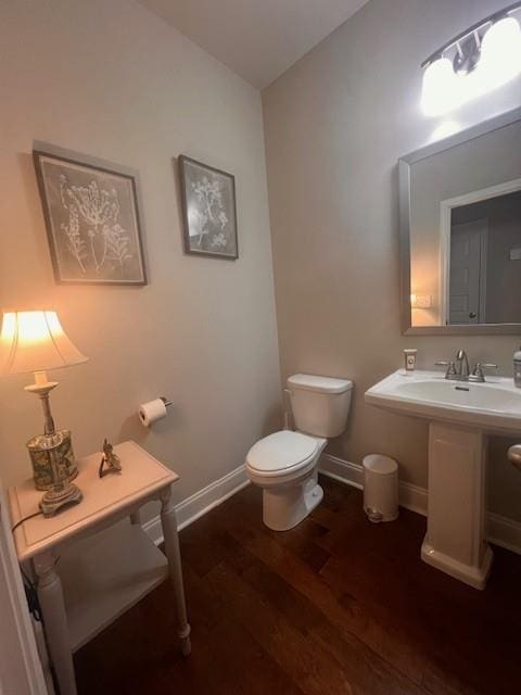 bathroom featuring baseboards, toilet, and wood finished floors