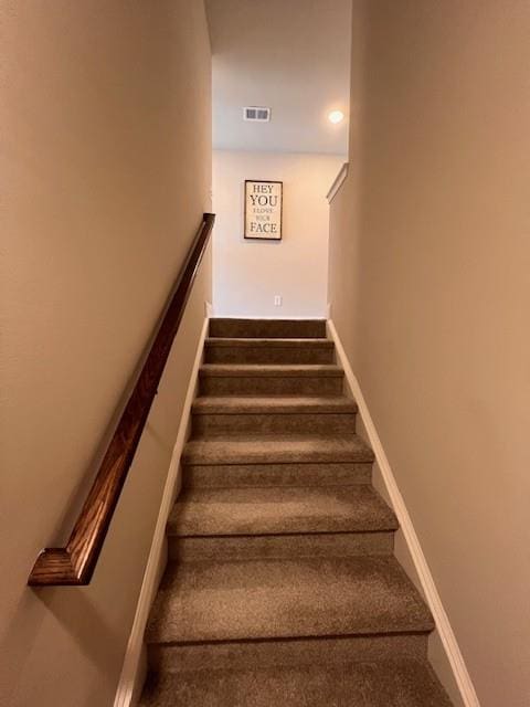 staircase featuring carpet, baseboards, and visible vents