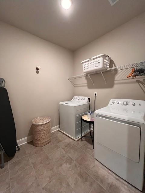 laundry room featuring laundry area, baseboards, and separate washer and dryer