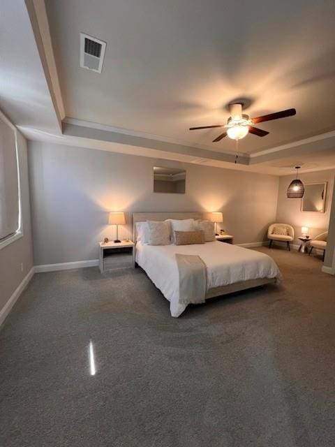 unfurnished bedroom featuring ceiling fan, baseboards, visible vents, and a raised ceiling