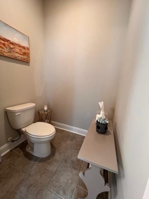 bathroom featuring baseboards and toilet