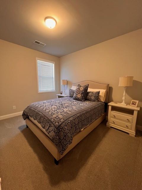 bedroom featuring baseboards, visible vents, and dark carpet