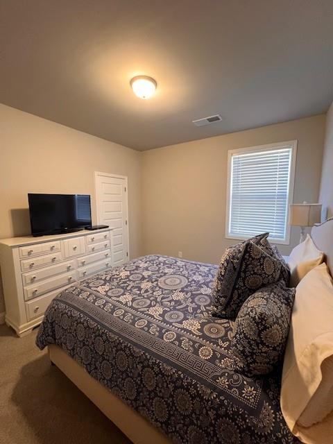 bedroom with light carpet and visible vents