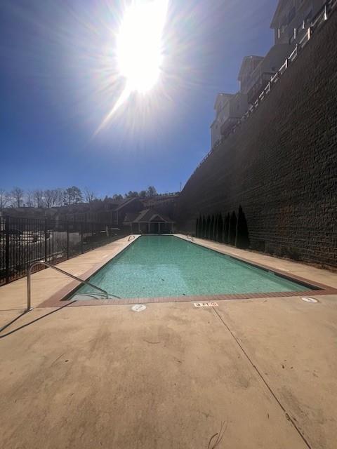 pool featuring a patio area and fence