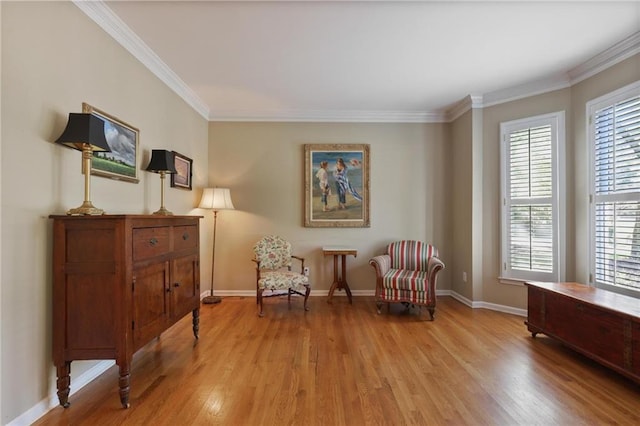 living area featuring light wood-type flooring and ornamental molding