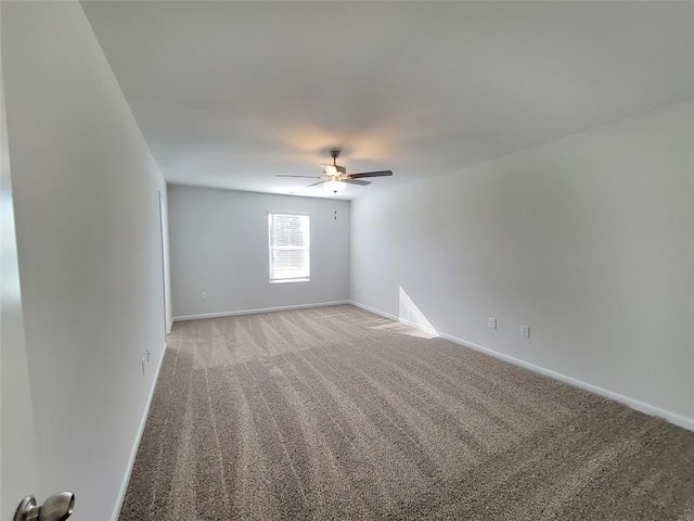 empty room featuring baseboards, ceiling fan, and light colored carpet