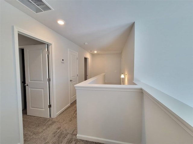 hallway with recessed lighting, light carpet, an upstairs landing, baseboards, and visible vents