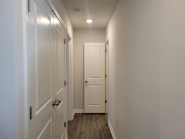 corridor with baseboards and dark wood-style flooring