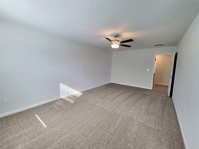 empty room with carpet floors, visible vents, and baseboards