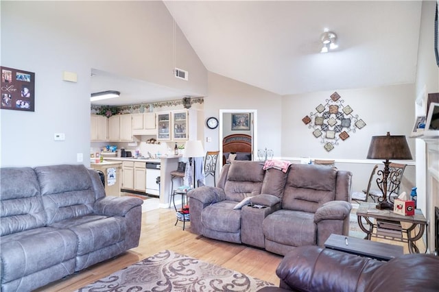 living room featuring light hardwood / wood-style flooring and high vaulted ceiling