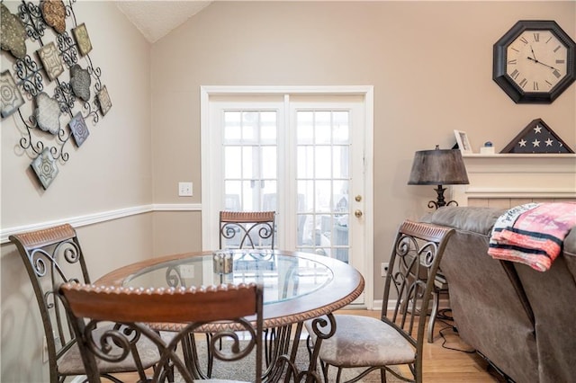 dining room with vaulted ceiling and light wood-type flooring