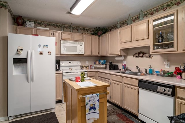 kitchen featuring sink, light brown cabinets, and white appliances