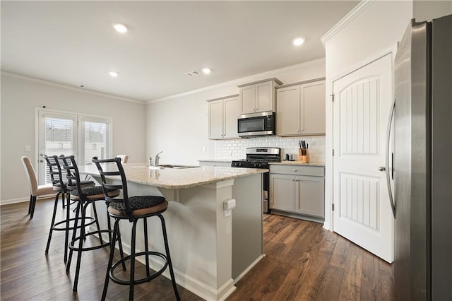 kitchen featuring a sink, gray cabinetry, a center island with sink, and stainless steel appliances