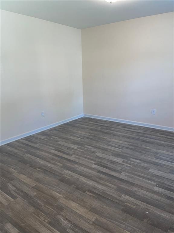 spare room featuring dark wood-type flooring